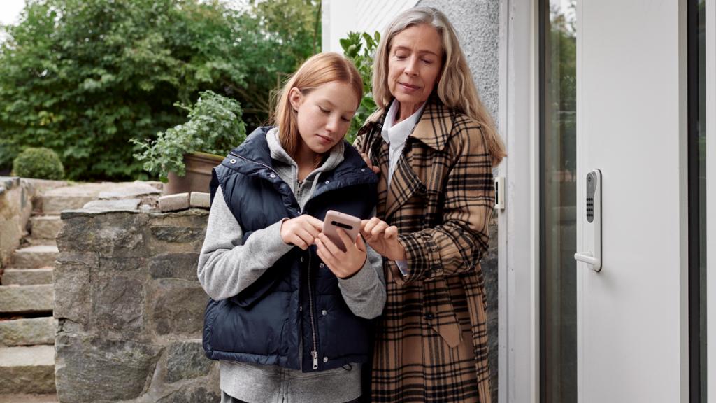 Femme et fille qui regardent un smartphone