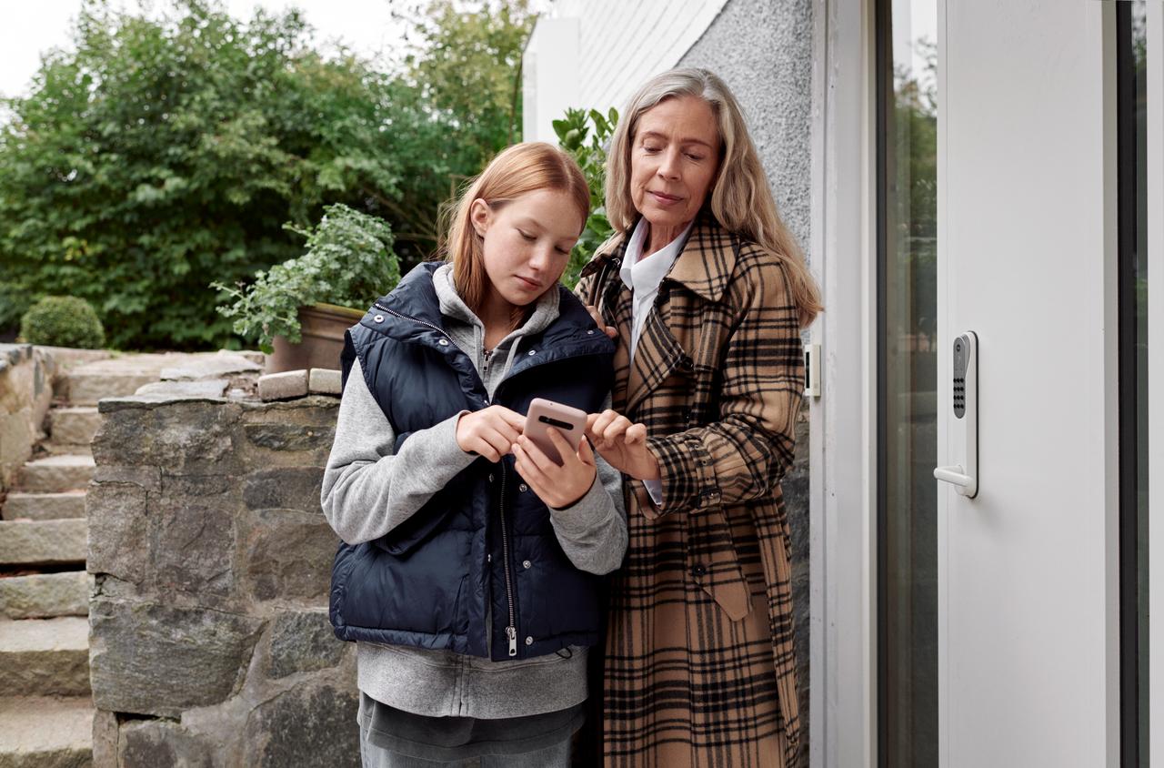 Femme et fille qui regardent un smartphone