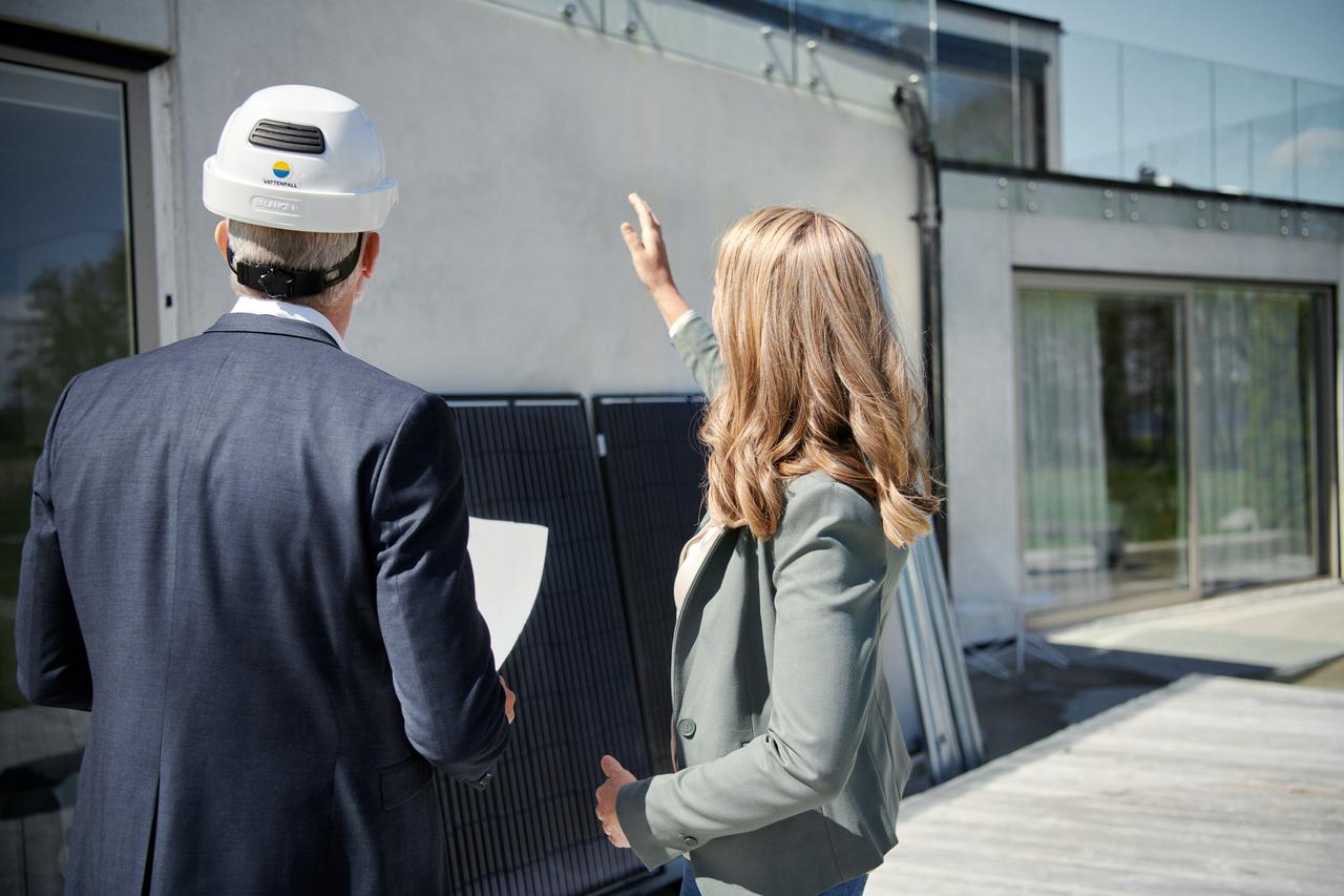 Employé travaillant dans les énergies renouvelables qui installe un panneau solaire chez une cliente